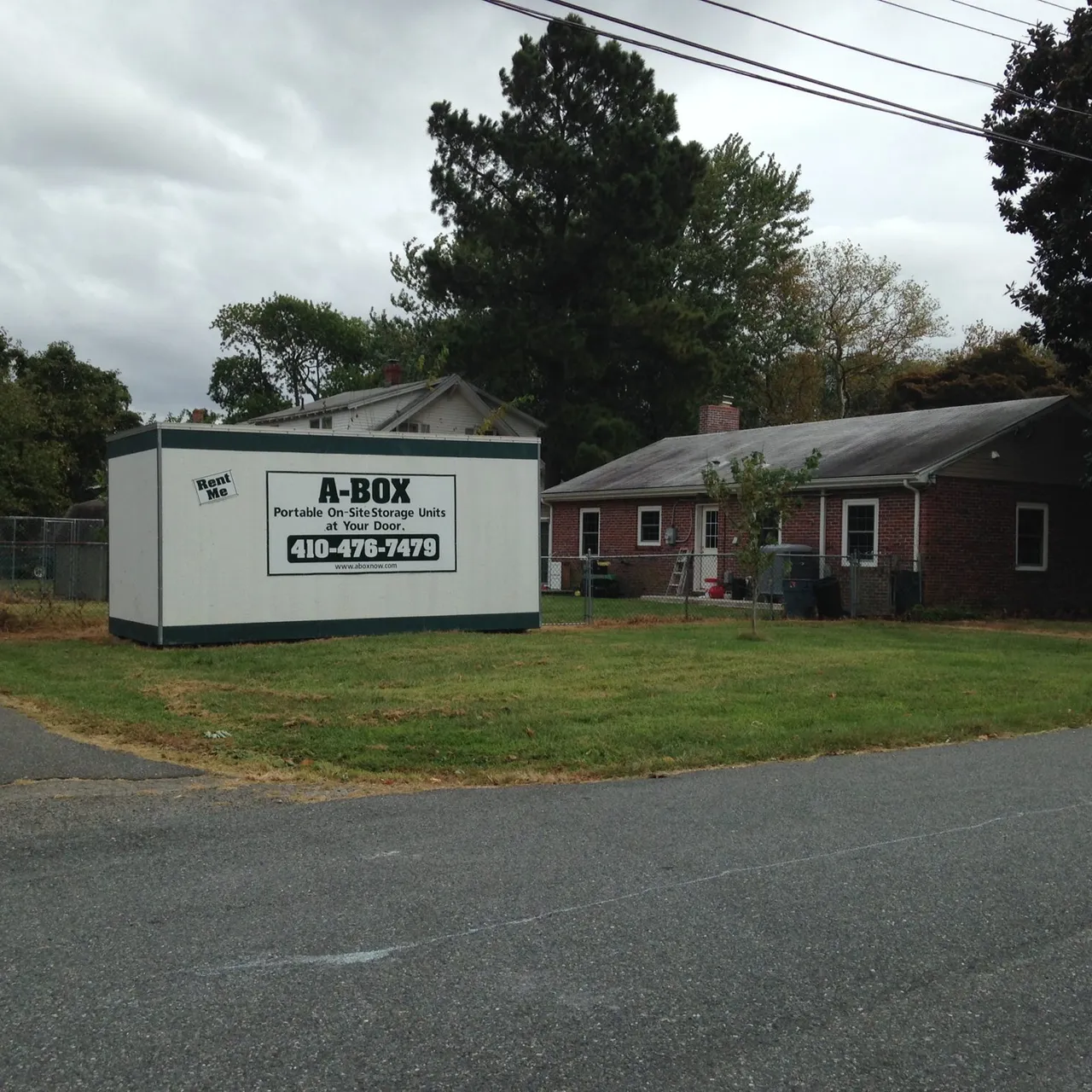 A Box portable storage container parked on the front lawn of a brick ranch home in Cambridge, Maryland