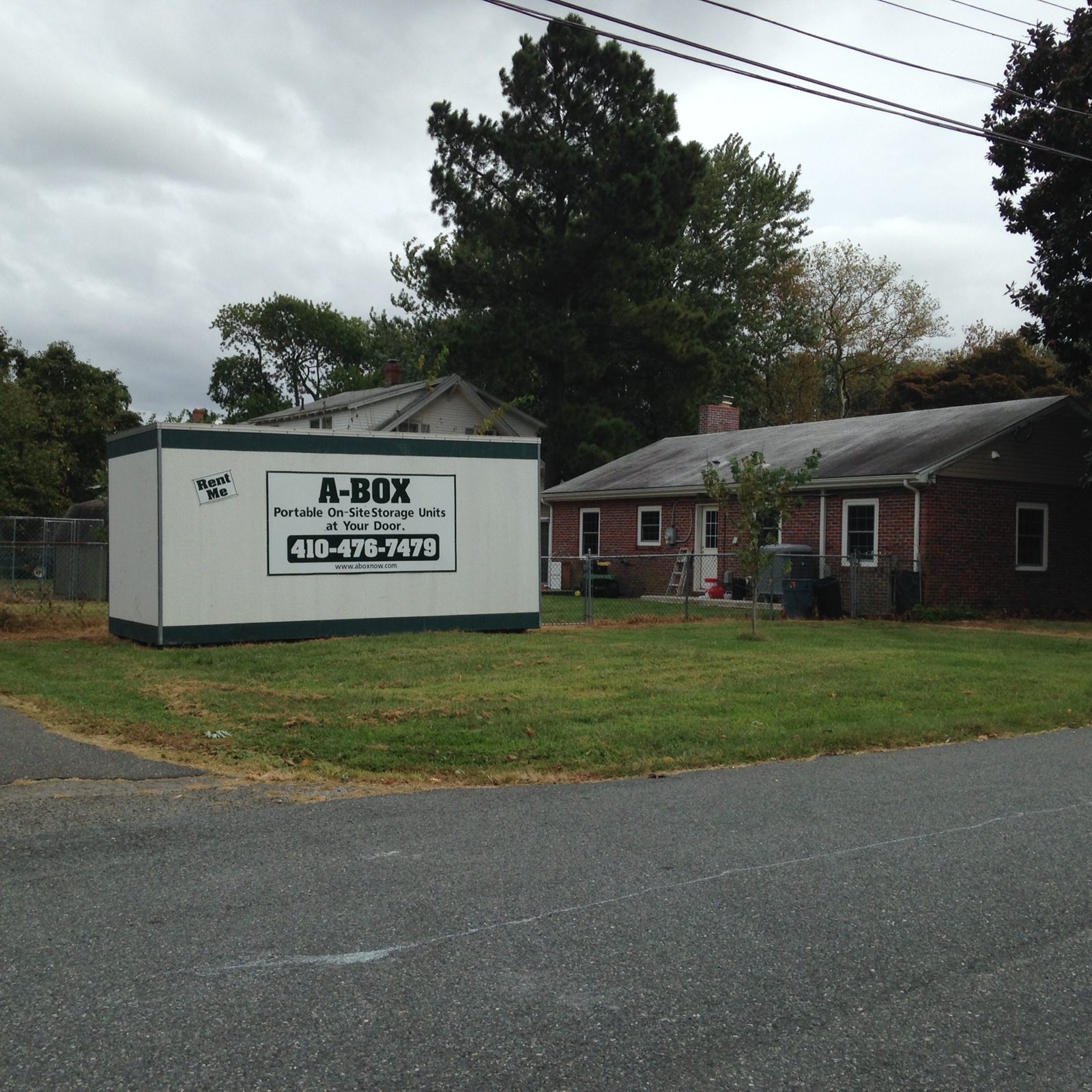 A Box portable storage container parked on the front lawn of a brick ranch home in Cambridge, Maryland