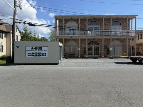 A Box portable storage container parked in front of a two-story brick commercial building on Maryland's Eastern Shore